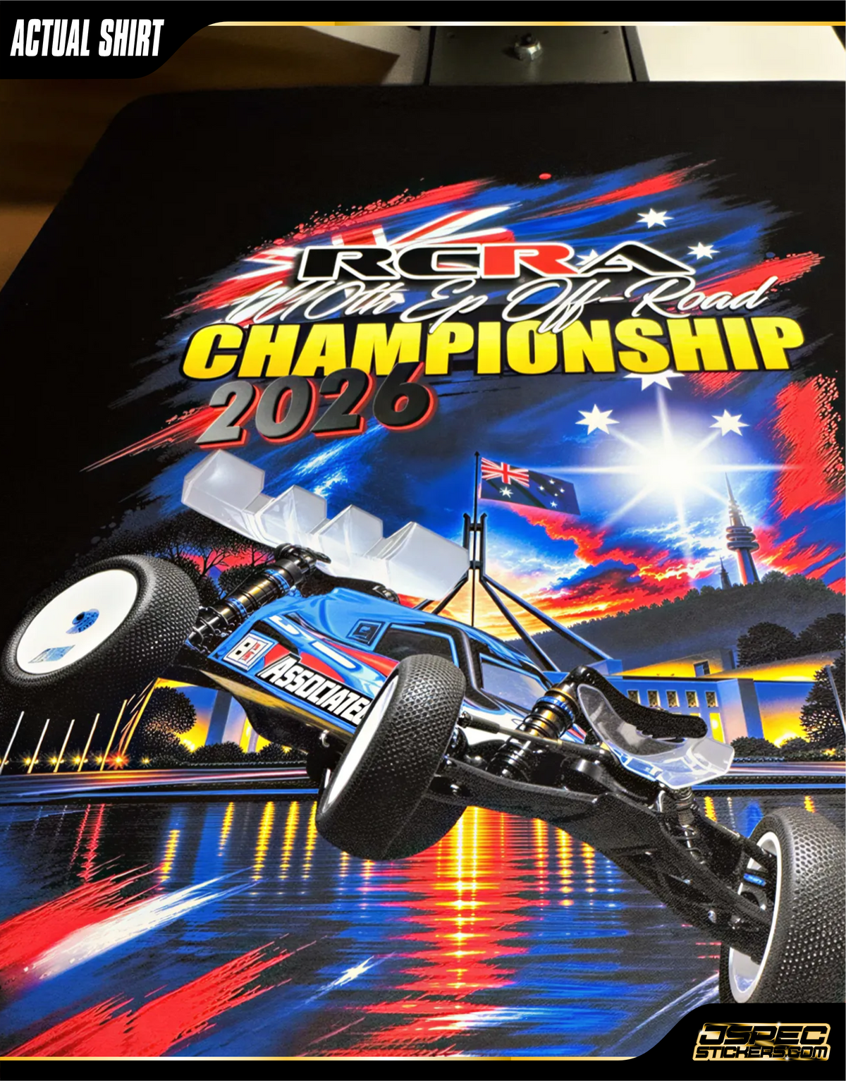 Black short-sleeve t-shirt shown from the rear with a large racing graphic print. The graphic features a blue and white off-road buggy, the text 'RCRA 2026', and Australian flag elements in red, white, and blue.